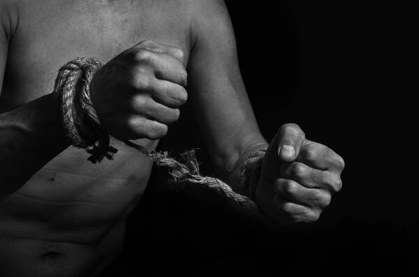 Man breaks the rope that bound his hands.