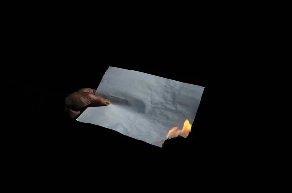 Burning sheet of paper in the male hand. — Stock Photo, Image