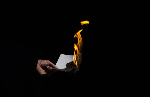 Feuille de papier brûlante dans la main masculine . — Photo