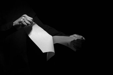 Bir kağıt parçasını yırtan adam.
