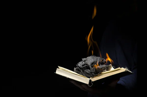 Man holds a burning book.