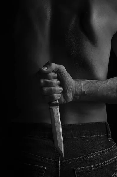 Mężczyzna chowa nóż za plecami. — Zdjęcie stockowe