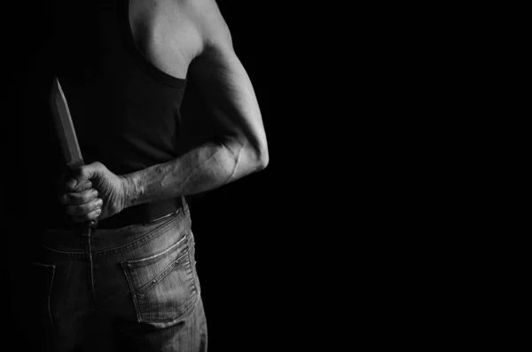 Hombre escondiendo un cuchillo detrás de su espalda — Foto de Stock