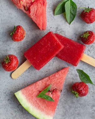 Ev yapımı karpuz çilekli buzlu dondurma. Taze meyve ve nane yapraklarıyla servis ediliyor. Tahta tepsi, üst manzara, yatay kompozisyon.