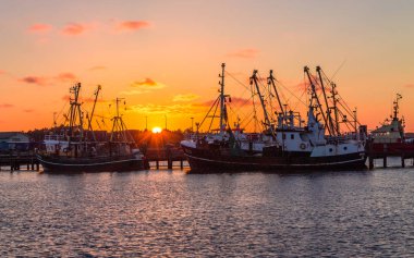 Eski balıkçı trol Harbour, Romo (Romo Havn) gün batımı sırasında üzerinde güzel, panoramik görünüm. Arka plan eski gemi, iskele ve ağaçların içinde. Yaz aylarında Danimarka.
