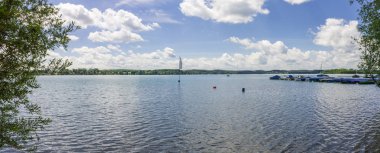 Panoramik deniz alınan güzel göl Wörthsee üzerinde. Yeşil-mavi bayrak, tekneler, iskele ve bitkiler açık, bulutlu bir günde, yatay. Woerthsee, Bavyera, Starnberg, Almanya.