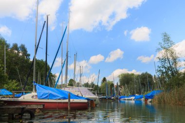Birçok tekneler, iskeleler ve su bitkileri ile güzel görünümü Harbour üzerinde. Wörthsee Bachern içinde. Su sporları için çok farklı gemi hazır. Kayık güneşli bir günde çekilmiş. Starnberg. Bavyera. Woerthsee