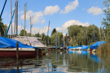 Birçok tekneler, iskeleler ve su bitkileri ile güzel görünümü Harbour üzerinde. Wörthsee Bachern içinde. Su sporları için çok farklı gemi hazır. Kayık güneşli bir günde çekilmiş. Woerthse, Starnberg. Bavyera.