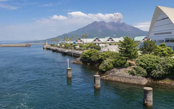 Entrance of Harbor Kagoshima with Sakurajima Port and Aquarium, the erupted Vulcan in the background. Taken from the Ferry. Located in Kagoshima, Kyushu, South of Japan. — Stock Photo, Image