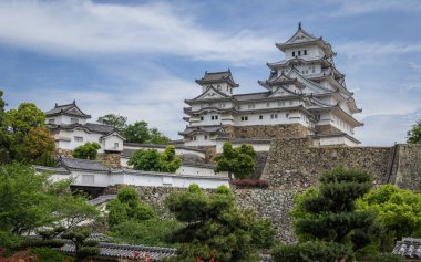 Yeşil bir manzara ve mavi gökyüzü içinde açık, güneşli bir gün üzerinde Himeji Kalesi kompleksi görüntüle. Himeji, Hyogo, Japonya, Asya.