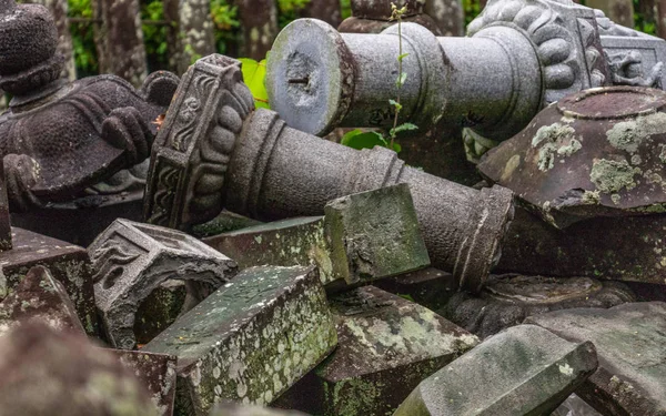 Muchos faroles de piedra rotos cerca de un camino a un templo budista en Japón. Templo Higo Honmyo, Prefectura de Kumamoto, Japón, Asia . — Foto de Stock