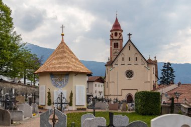 Ana kilise Panoraması, Pfarrkirche St. Johannes der Taufer, Tirol belediye köyünde mezarlık ve Şapel ile. Tirolo, Güney Tyrol, Italya. Avrupa.
