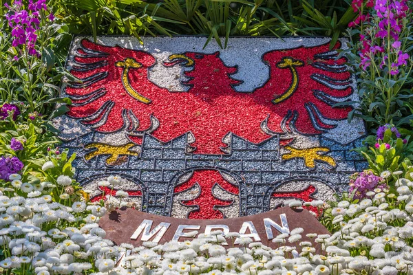 Detailní pohled na přírodní hřeben, emblém, vlajka města Meran v květinkové posteli. Merano. Provincie Bolzano, Jižní Tyrolsko, Itálie. Evropě. — Stock fotografie