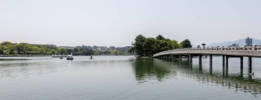 Ünlü Brigde, ada ve gölet faaliyetleri ile Ohori Park Panorama görünümü. Chuo-ku, Fukuoka, Japonya, Asya.