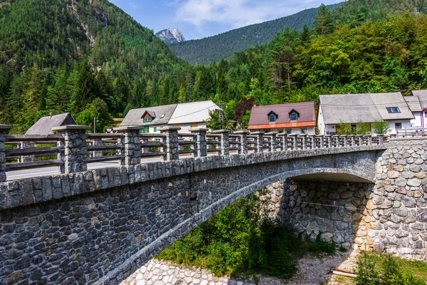 Puente sobre el río Predelica desde el paso Predil en la cabaña de troncos del pueblo Mangartom. Bovec, Eslovenia, Europa . — Foto de Stock