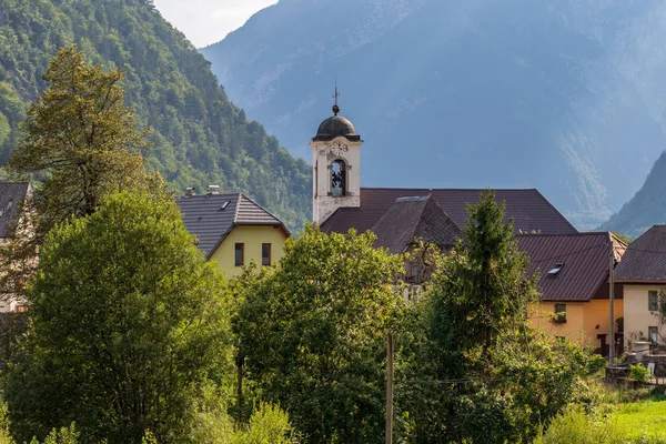 Binalar ile Panorama ve Köy Log pod Mangartom Dağ Manzara içinde Parish Kilisesi. Bovec, Slovenya, Avrupa. — Stok fotoğraf