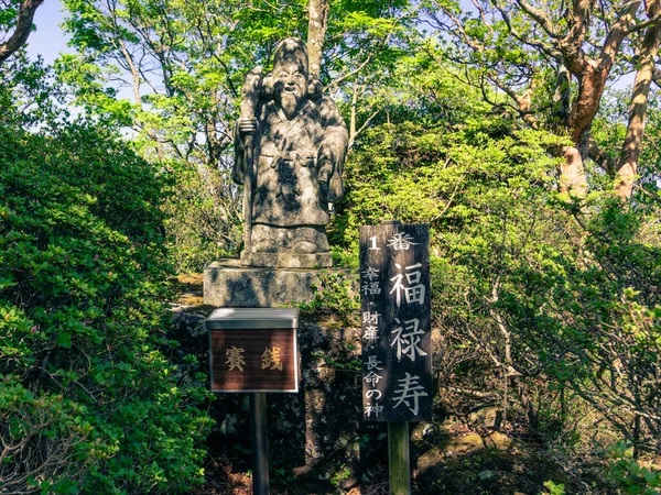 Buddha Statue Number 1 with explanation sign of the Buddha Path on the Top of Mount Tsurumi. Beppu, Oita Prefecture, Japan. — Stock Photo, Image