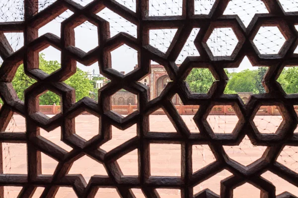 Окно вырезанного михраба внутри гробницы Хумейни. Ворота на заднем плане в Дели, Индия. Азия . — стоковое фото