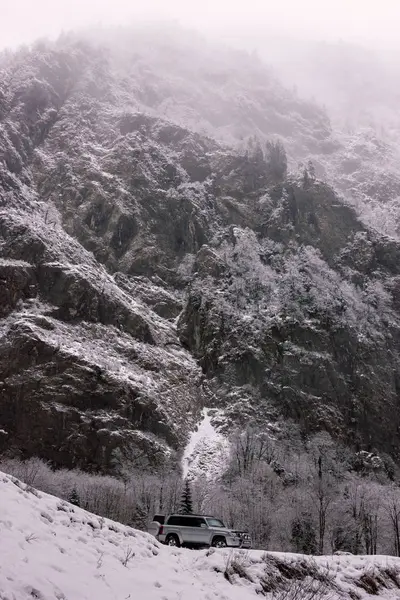 Kışın dağ eğim ve uzaktan bir araba. Abhazya, Gürcistan
