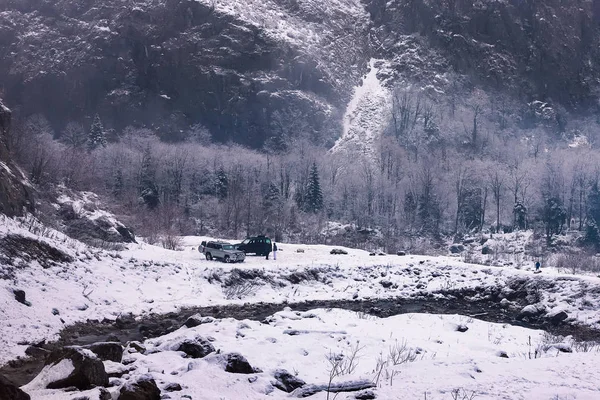 Kışın dağ eğim ve uzaktan bir araba. Abhazya, Gürcistan