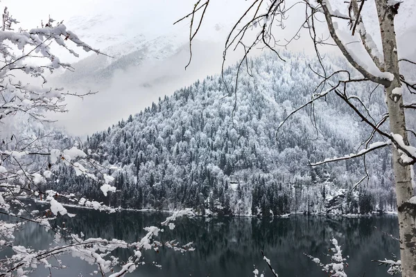 Beautiful winter lake Ritsa framed by branches