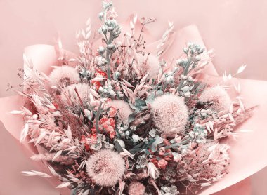 Bir buket pembe tonlarda dandelions ve spikelets ile kağıt sarılı kurutulmuş çiçek