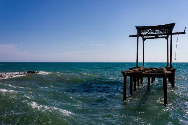 Ufuk açık gün hava, dalgalar ve berrak gökyüzü manzaralı eski terk edilmiş deniz İskelesi