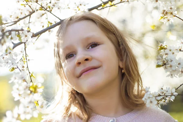 春天树上可爱漂亮的小女孩的肖像 可爱的小女孩在阳光明媚的花园里微笑 展望未来 自然柔情 儿童节做梦 — 图库照片