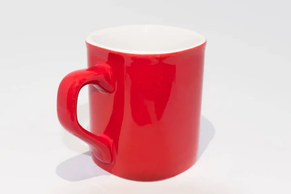 Vazio copo de café vermelho e branco em um fundo branco — Fotografia de Stock