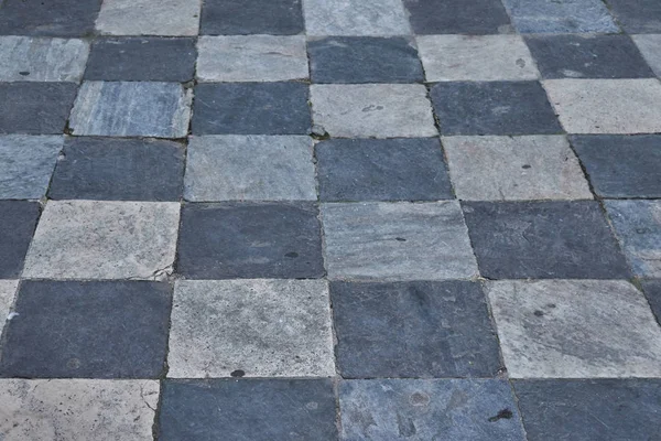 Kamenná dlažba z černé a bílé čtverečky v Toledu, Španělsko. Textura nebo pozadí — Stock fotografie