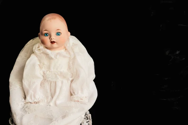 Primer plano de muñeca infantil de porcelana vieja con ojos azules sobre fondo negro — Foto de Stock