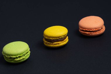 Kırmızı, yeşil ve sarı renklerin iştah açıcı makarnası siyah arkaplanda çapraz olarak sıralanır..