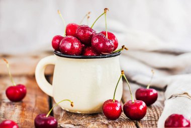 Bir kupa rustik adam üzerinde taze olgun kiraz