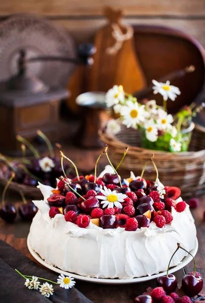 美味的帕夫洛娃酥皮蛋糕 装饰新鲜的覆盆子和樱桃在乡村背景下 — 图库照片