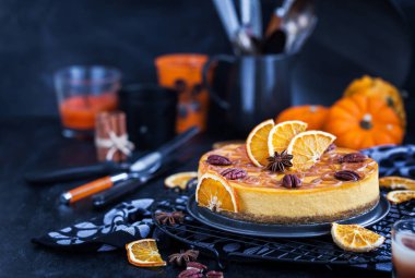 Delicious pumpkin and orange cheesecake decorated with caramel sauce and pecan clipart