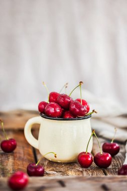Bir kupa rustik adam üzerinde taze olgun kiraz