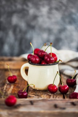 Bir kupa rustik adam üzerinde taze olgun kiraz