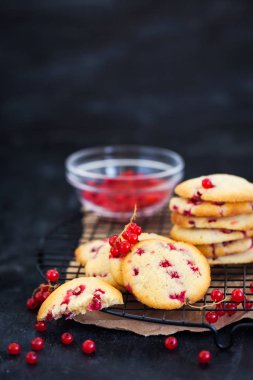Koyu arka plan üzerinde kırmızı kuş üzümü ile taze ev yapımı kurabiye