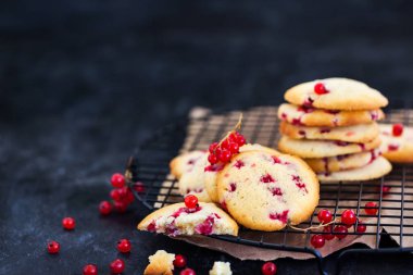 Koyu arka plan üzerinde kırmızı kuş üzümü ile taze ev yapımı kurabiye