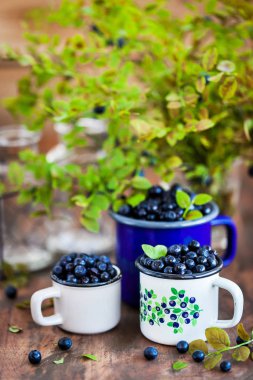Emaye kupalar içinde taze olgun bluberries (bilberries) 