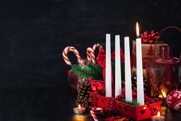 つのクリスマス アドベントろうそくや暗い背景に周りの休日の装飾 — ストック写真