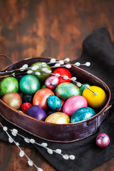 Pascua coloridos huevos pintados y sauce sobre fondo rústico oscuro —  Fotos de Stock