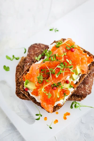 Salted salmon, red caviar, avocado and cream cheese rye crisp to — Stock Photo, Image