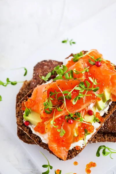 Salted salmon, red caviar, avocado and cream cheese rye crisp to — Stock Photo, Image