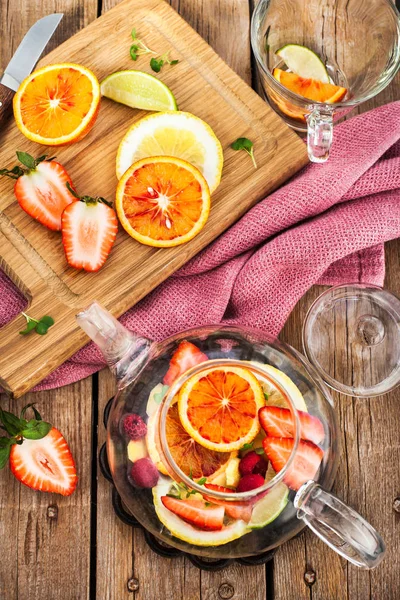 Té rojo de frutas con naranjas y bayas en la mesa de madera, vista superior — Foto de Stock