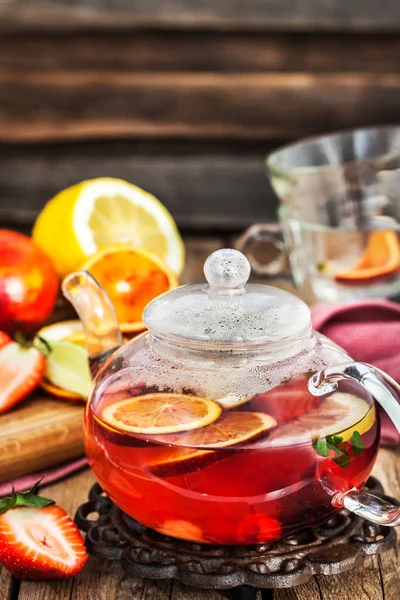 Фруктовий червоний чай з апельсинами та ягодами на дерев'яному столі — стокове фото