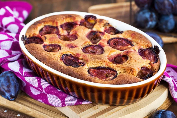 Fresh homemade dimply plum cake on rustic background — Stock Photo, Image