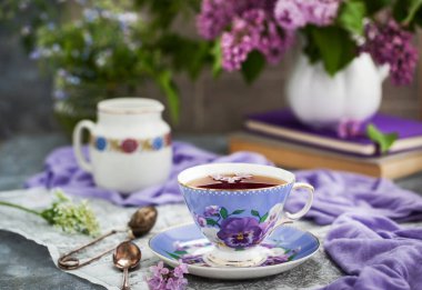 Gri arka planda mor çay ve leylak.