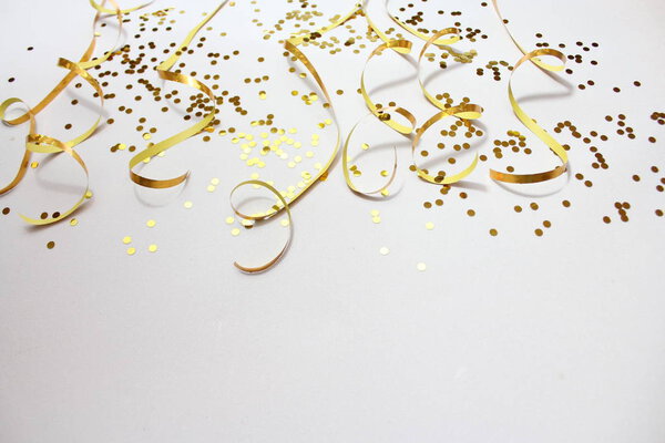 golden paperstreamer and confetti on white background