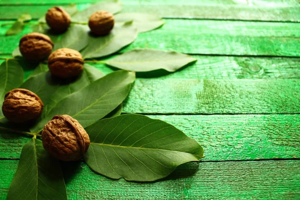 walnuts and walnut leaves on green boards